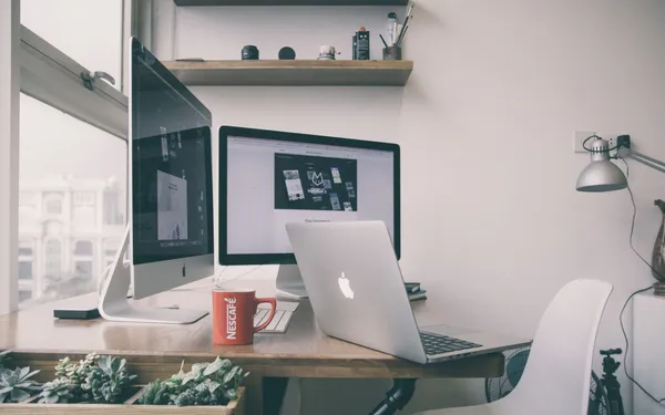 Contemporary apartment workspace with a laptop, lamp and warm window light