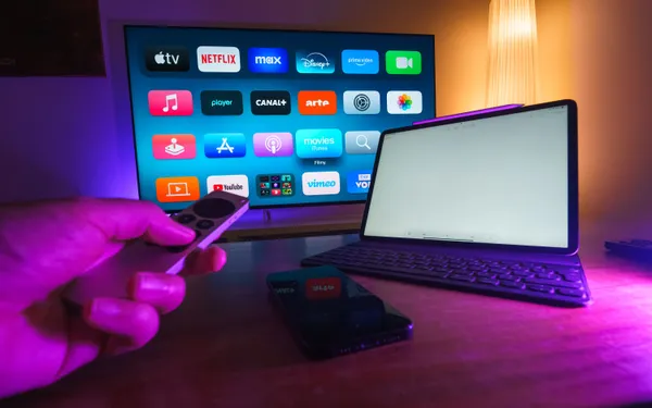 Split-screen comparison of live TV streaming and an on-demand library in a warm modern UK living room