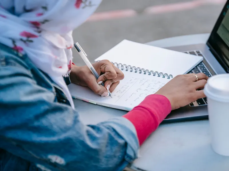 Student writing a message on a laptop at a warm desk
