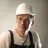 Content&nbsp;male&nbsp;builder&nbsp;in&nbsp;workwear&nbsp;and&nbsp;hardhat&nbsp;smiling&nbsp;on&nbsp;gray&nbsp;background&nbsp;in&nbsp;studio&nbsp;and&nbsp;looking&nbsp;at&nbsp;camera