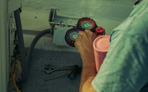 A&nbsp;technician&nbsp;checks&nbsp;and&nbsp;repairs&nbsp;an&nbsp;HVAC&nbsp;system&nbsp;outdoors&nbsp;using&nbsp;tools&nbsp;and&nbsp;gauges.