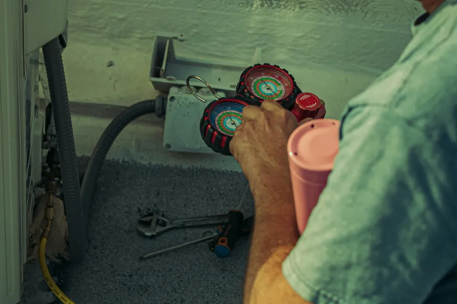 A&nbsp;technician&nbsp;checks&nbsp;and&nbsp;repairs&nbsp;an&nbsp;HVAC&nbsp;system&nbsp;outdoors&nbsp;using&nbsp;tools&nbsp;and&nbsp;gauges.