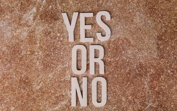Wooden&nbsp;letters&nbsp;on&nbsp;marble&nbsp;background&nbsp;spell&nbsp;'YES&nbsp;OR&nbsp;NO'&nbsp;symbolizing&nbsp;choices.