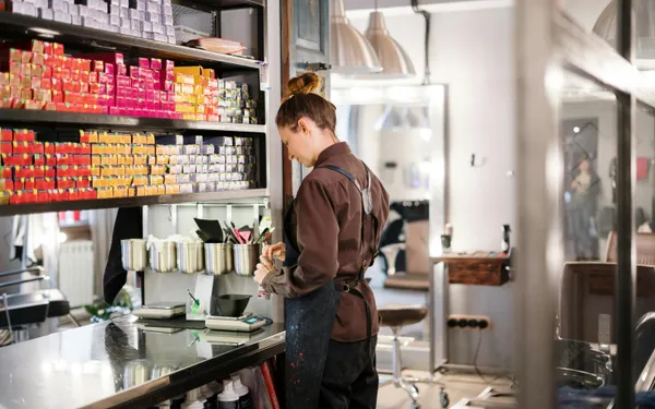 Hairdresser&nbsp;organizing&nbsp;hair&nbsp;color&nbsp;products&nbsp;in&nbsp;a&nbsp;modern&nbsp;salon.