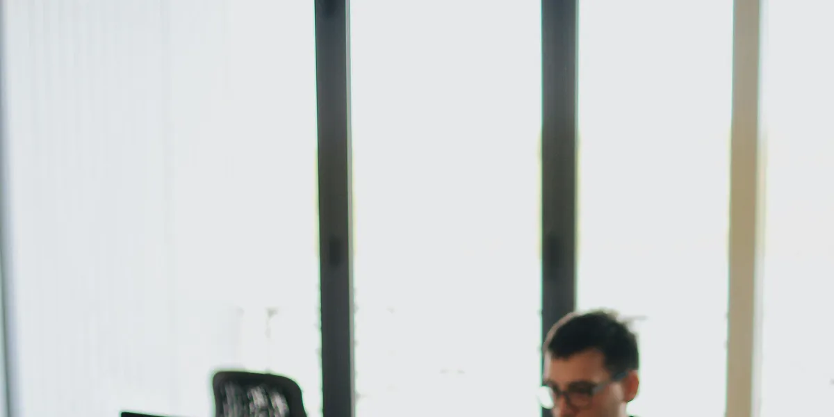 A&nbsp;web&nbsp;developer&nbsp;working&nbsp;on&nbsp;code&nbsp;in&nbsp;a&nbsp;modern&nbsp;office&nbsp;setting&nbsp;with&nbsp;multiple&nbsp;devices.