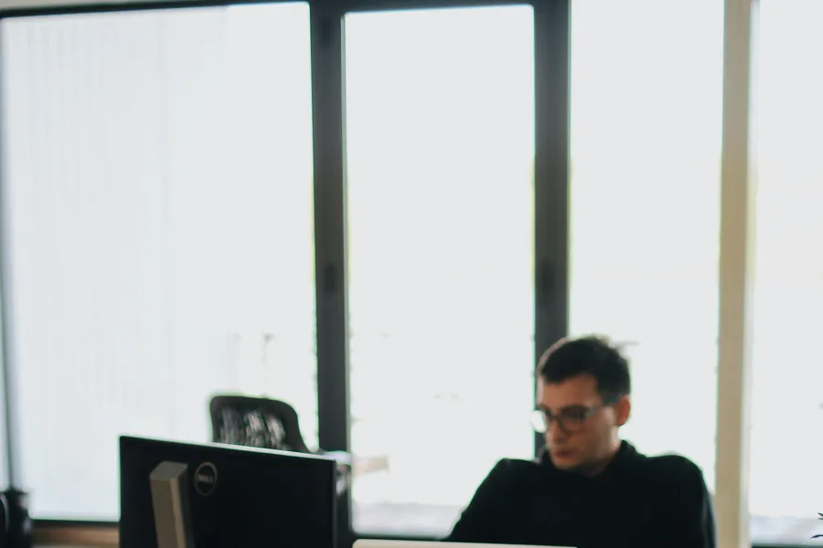 A&nbsp;web&nbsp;developer&nbsp;working&nbsp;on&nbsp;code&nbsp;in&nbsp;a&nbsp;modern&nbsp;office&nbsp;setting&nbsp;with&nbsp;multiple&nbsp;devices.