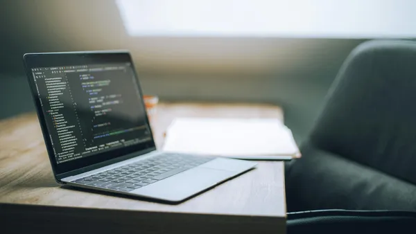 Open&nbsp;laptop&nbsp;displaying&nbsp;code&nbsp;on&nbsp;desk&nbsp;in&nbsp;bright,&nbsp;modern&nbsp;office&nbsp;setting.&nbsp;Ideal&nbsp;for&nbsp;tech&nbsp;and&nbsp;remote&nbsp;work&nbsp;context.