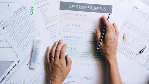 Hands&nbsp;organizing&nbsp;business&nbsp;documents&nbsp;and&nbsp;pricing&nbsp;formula&nbsp;papers&nbsp;on&nbsp;an&nbsp;office&nbsp;desk.