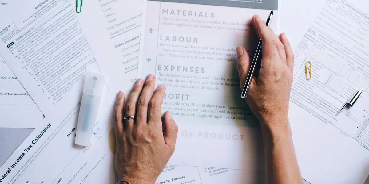 Hands&nbsp;organizing&nbsp;business&nbsp;documents&nbsp;and&nbsp;pricing&nbsp;formula&nbsp;papers&nbsp;on&nbsp;an&nbsp;office&nbsp;desk.