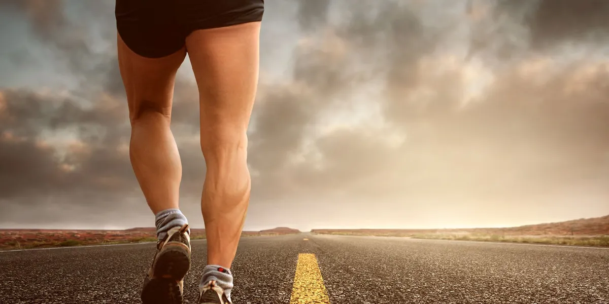 Runner's&nbsp;legs&nbsp;on&nbsp;a&nbsp;road&nbsp;during&nbsp;a&nbsp;sunset,&nbsp;symbolizing&nbsp;endurance&nbsp;and&nbsp;outdoor&nbsp;fitness&nbsp;training.