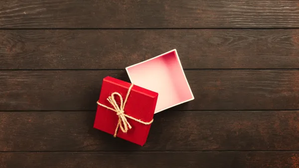 Top&nbsp;view&nbsp;of&nbsp;an&nbsp;open&nbsp;red&nbsp;gift&nbsp;box&nbsp;tied&nbsp;with&nbsp;twine&nbsp;on&nbsp;a&nbsp;wooden&nbsp;surface.