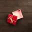 Top&nbsp;view&nbsp;of&nbsp;an&nbsp;open&nbsp;red&nbsp;gift&nbsp;box&nbsp;tied&nbsp;with&nbsp;twine&nbsp;on&nbsp;a&nbsp;wooden&nbsp;surface.