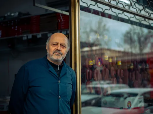 Small&nbsp;business&nbsp;owner&nbsp;standing&nbsp;outside&nbsp;a&nbsp;neighborhood&nbsp;storefront