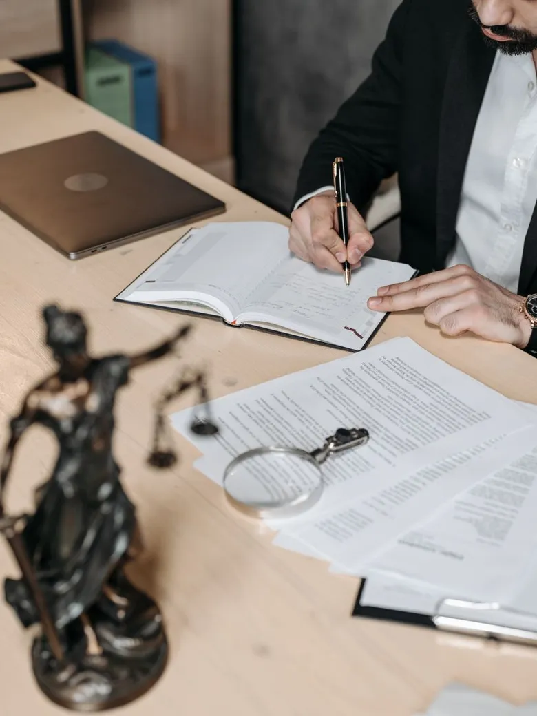 A lawyer reviews documents at a desk in a light-filled office.