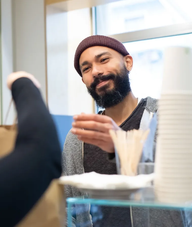 A customer at the counter of a neighborhood cafe