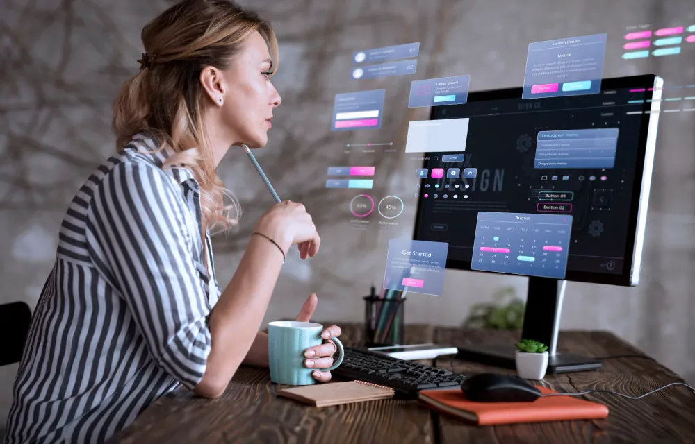 A&nbsp;designer&nbsp;plans&nbsp;a&nbsp;website&nbsp;beside&nbsp;a&nbsp;screen&nbsp;of&nbsp;interface&nbsp;concepts