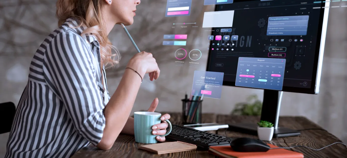 A&nbsp;designer&nbsp;plans&nbsp;a&nbsp;website&nbsp;beside&nbsp;a&nbsp;screen&nbsp;of&nbsp;interface&nbsp;concepts