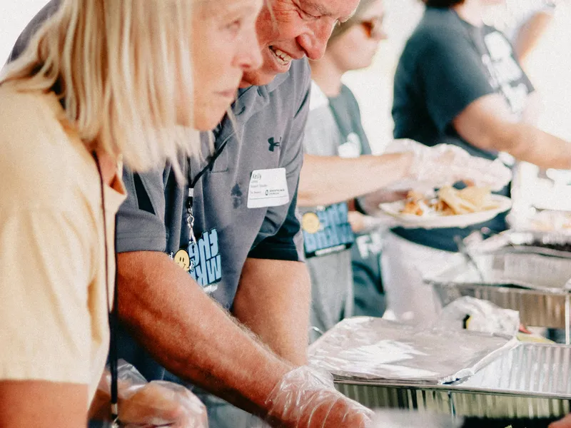 People&nbsp;serving&nbsp;food&nbsp;at&nbsp;a&nbsp;community&nbsp;church&nbsp;event&nbsp;outdoors.
