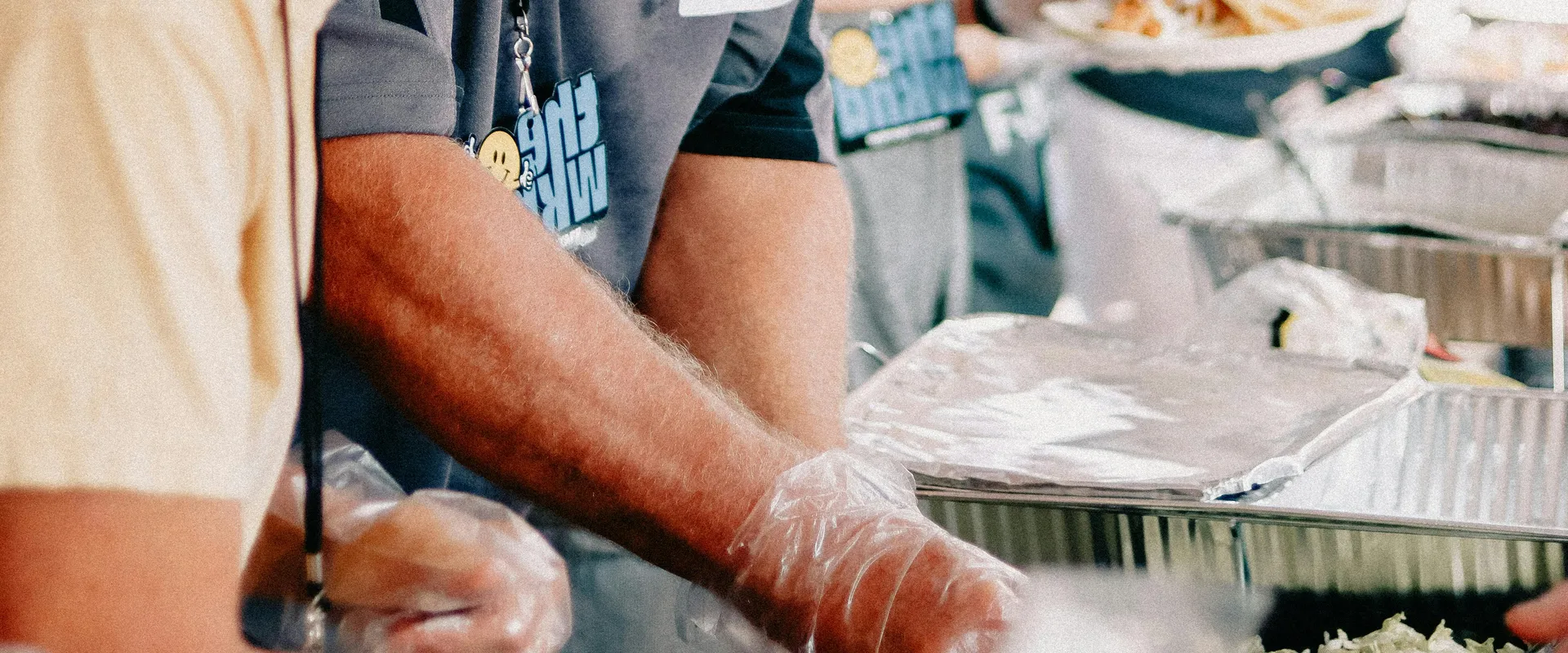 People&nbsp;serving&nbsp;food&nbsp;at&nbsp;a&nbsp;community&nbsp;church&nbsp;event&nbsp;outdoors.
