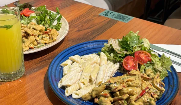 A&nbsp;vibrant&nbsp;vegan&nbsp;meal&nbsp;featuring&nbsp;pasta,&nbsp;salad,&nbsp;and&nbsp;juice,&nbsp;perfect&nbsp;for&nbsp;health-conscious&nbsp;eating.