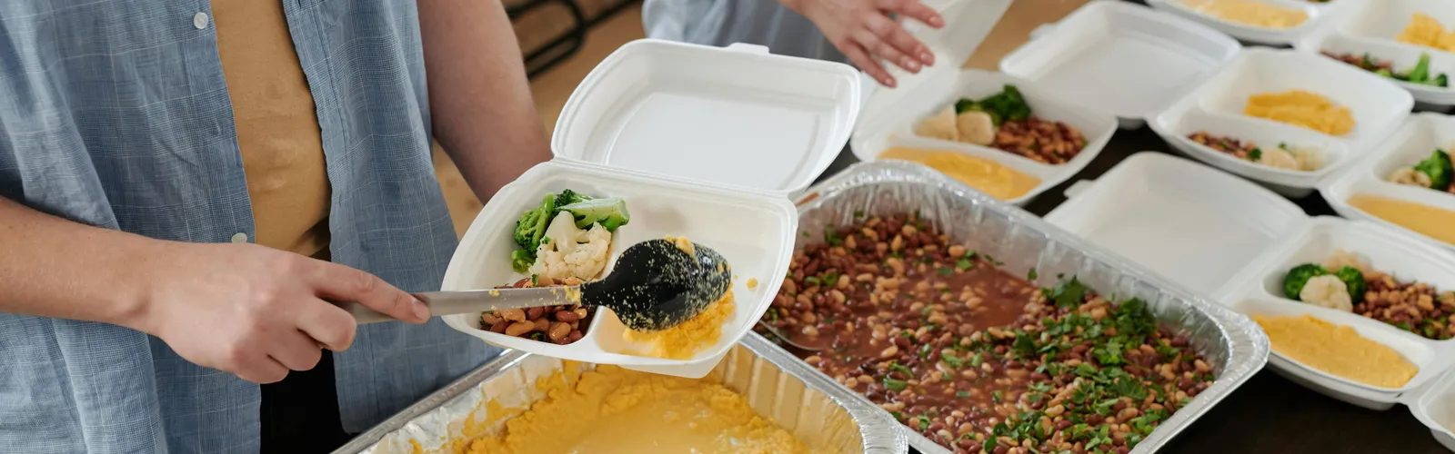 Volunteers&nbsp;preparing&nbsp;food&nbsp;packs&nbsp;indoors&nbsp;for&nbsp;donation.