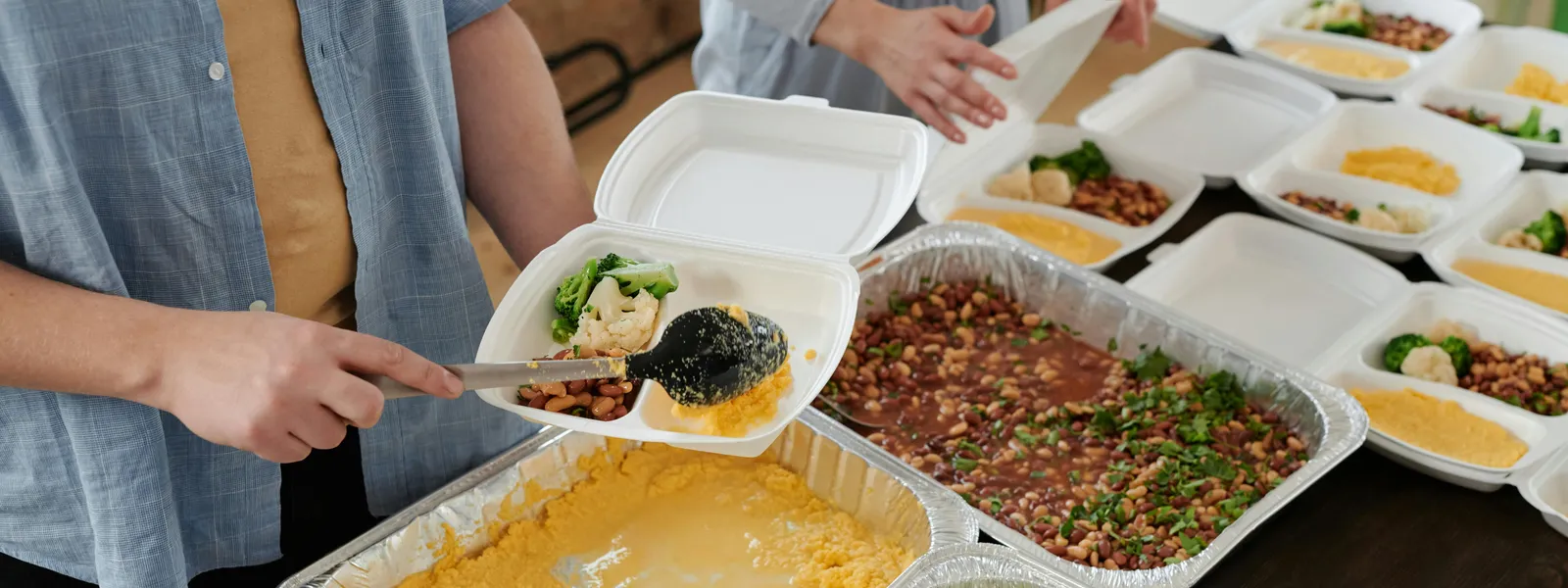 Volunteers&nbsp;preparing&nbsp;food&nbsp;packs&nbsp;indoors&nbsp;for&nbsp;donation.