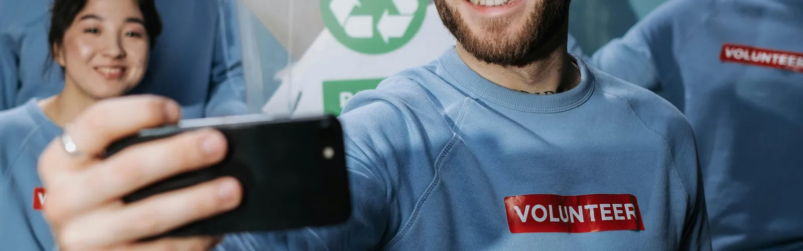 A&nbsp;diverse&nbsp;group&nbsp;of&nbsp;volunteers&nbsp;in&nbsp;blue&nbsp;shirts&nbsp;taking&nbsp;a&nbsp;selfie&nbsp;during&nbsp;a&nbsp;community&nbsp;service&nbsp;event.