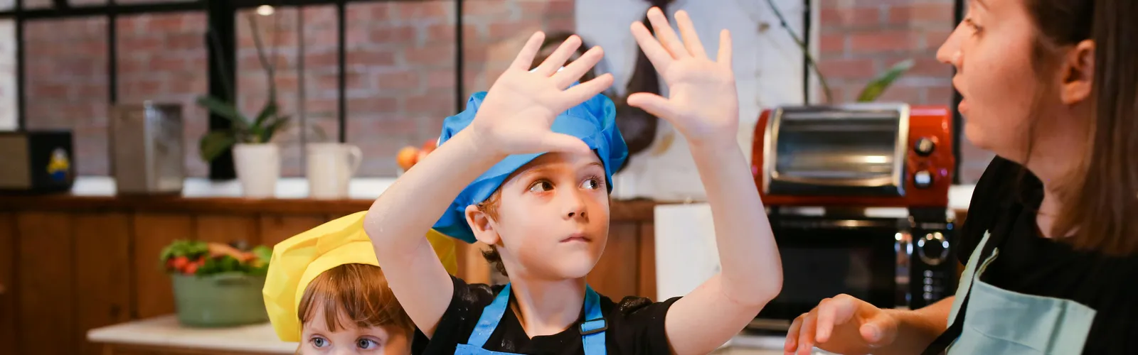 Kids&nbsp;having&nbsp;fun&nbsp;in&nbsp;a&nbsp;baking&nbsp;class,&nbsp;learning&nbsp;to&nbsp;make&nbsp;cookies&nbsp;together&nbsp;with&nbsp;an&nbsp;instructor.