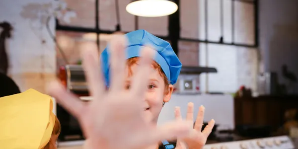 Children&nbsp;enjoying&nbsp;a&nbsp;hands-on&nbsp;cooking&nbsp;class,&nbsp;wearing&nbsp;chef&nbsp;hats&nbsp;and&nbsp;aprons&nbsp;in&nbsp;a&nbsp;cozy&nbsp;kitchen&nbsp;setting.