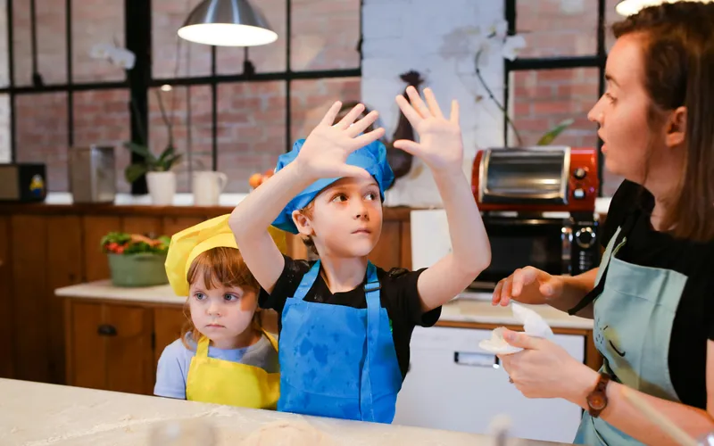 Kids&nbsp;having&nbsp;fun&nbsp;in&nbsp;a&nbsp;baking&nbsp;class,&nbsp;learning&nbsp;to&nbsp;make&nbsp;cookies&nbsp;together&nbsp;with&nbsp;an&nbsp;instructor.