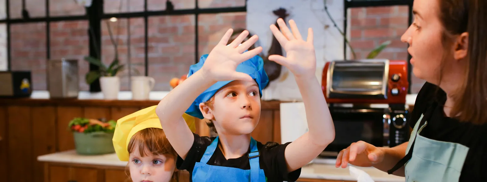 Kids&nbsp;having&nbsp;fun&nbsp;in&nbsp;a&nbsp;baking&nbsp;class,&nbsp;learning&nbsp;to&nbsp;make&nbsp;cookies&nbsp;together&nbsp;with&nbsp;an&nbsp;instructor.