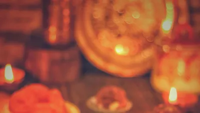 A&nbsp;warm&nbsp;display&nbsp;of&nbsp;Indian&nbsp;sweets&nbsp;and&nbsp;diyas&nbsp;celebrating&nbsp;a&nbsp;festive&nbsp;occasion&nbsp;indoors.