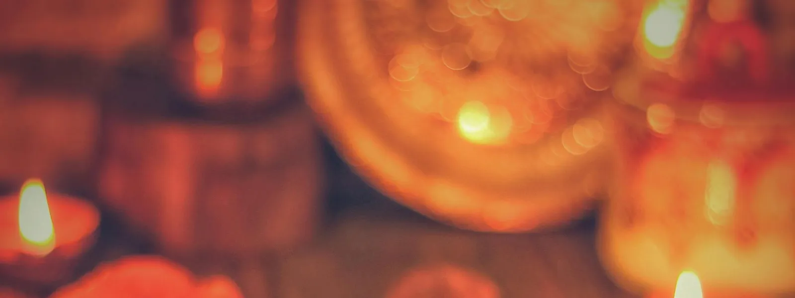 A&nbsp;warm&nbsp;display&nbsp;of&nbsp;Indian&nbsp;sweets&nbsp;and&nbsp;diyas&nbsp;celebrating&nbsp;a&nbsp;festive&nbsp;occasion&nbsp;indoors.