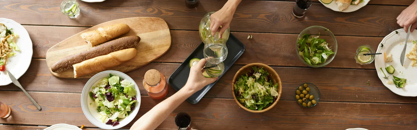 An&nbsp;overhead&nbsp;shot&nbsp;of&nbsp;a&nbsp;dining&nbsp;table&nbsp;featuring&nbsp;various&nbsp;pasta&nbsp;dishes&nbsp;and&nbsp;salads&nbsp;shared&nbsp;by&nbsp;a&nbsp;group.
