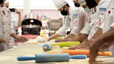 Trainees&nbsp;working&nbsp;at&nbsp;stations&nbsp;in&nbsp;a&nbsp;professional&nbsp;kitchen&nbsp;during&nbsp;a&nbsp;job&nbsp;training&nbsp;session.