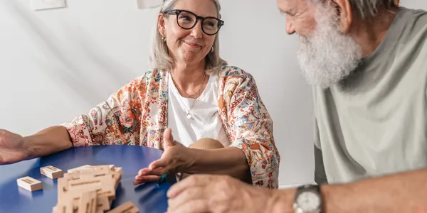 Senior&nbsp;citizens&nbsp;laughing&nbsp;together&nbsp;over&nbsp;a&nbsp;shared&nbsp;meal&nbsp;and&nbsp;board&nbsp;games