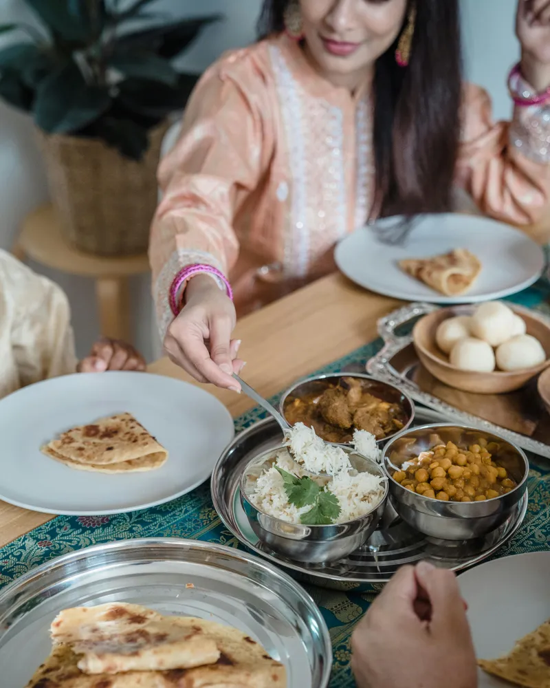 Enjoying&nbsp;Indian&nbsp;cuisine&nbsp;together&nbsp;with&nbsp;family&nbsp;at&nbsp;home,&nbsp;sharing&nbsp;naan,&nbsp;curry,&nbsp;and&nbsp;rice.