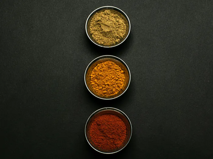 Top&nbsp;view&nbsp;of&nbsp;assorted&nbsp;spice&nbsp;powders&nbsp;in&nbsp;metal&nbsp;bowls&nbsp;showcasing&nbsp;vibrant&nbsp;colors&nbsp;against&nbsp;a&nbsp;dark&nbsp;background.