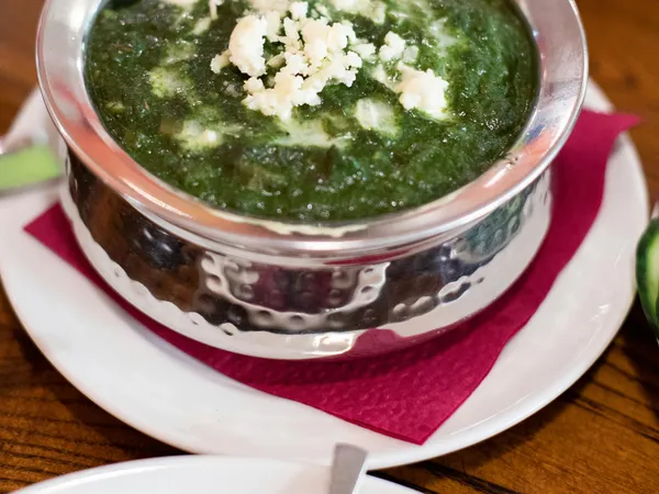Top-down&nbsp;view&nbsp;of&nbsp;creamy&nbsp;palak&nbsp;paneer&nbsp;served&nbsp;in&nbsp;a&nbsp;stainless&nbsp;steel&nbsp;bowl,&nbsp;garnished&nbsp;with&nbsp;crumbled&nbsp;cheese.