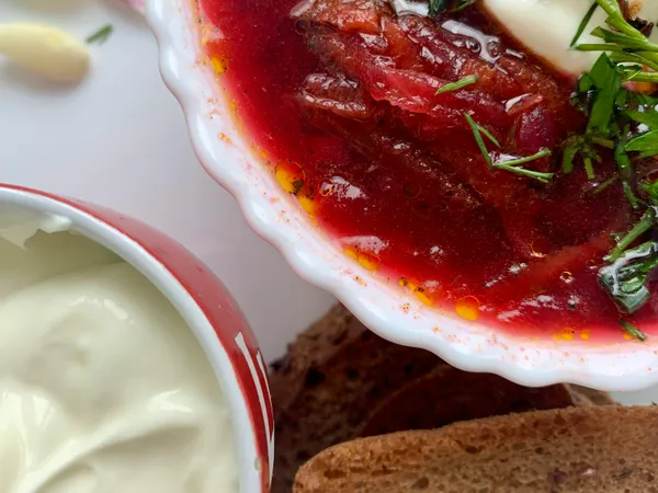 Close-up&nbsp;of&nbsp;borscht&nbsp;soup&nbsp;with&nbsp;sour&nbsp;cream&nbsp;and&nbsp;dill,&nbsp;served&nbsp;with&nbsp;rye&nbsp;bread.
