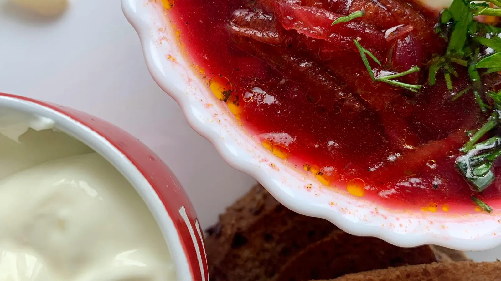 Close-up&nbsp;of&nbsp;borscht&nbsp;soup&nbsp;with&nbsp;sour&nbsp;cream&nbsp;and&nbsp;dill,&nbsp;served&nbsp;with&nbsp;rye&nbsp;bread.