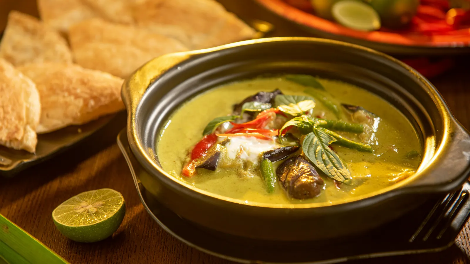 A&nbsp;flavorful&nbsp;Thai&nbsp;green&nbsp;curry&nbsp;with&nbsp;vegetables&nbsp;and&nbsp;aromatic&nbsp;herbs&nbsp;in&nbsp;a&nbsp;stylish&nbsp;black&nbsp;bowl.
