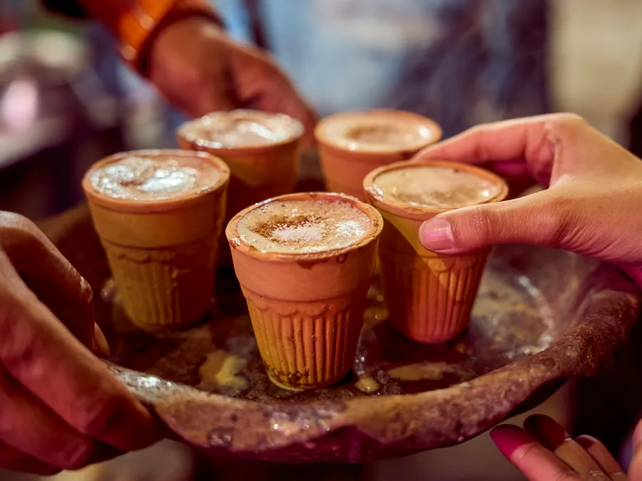 Close-up&nbsp;of&nbsp;masala&nbsp;chai&nbsp;served&nbsp;in&nbsp;clay&nbsp;cups&nbsp;by&nbsp;a&nbsp;street&nbsp;vendor,&nbsp;capturing&nbsp;authentic&nbsp;Indian&nbsp;culture.