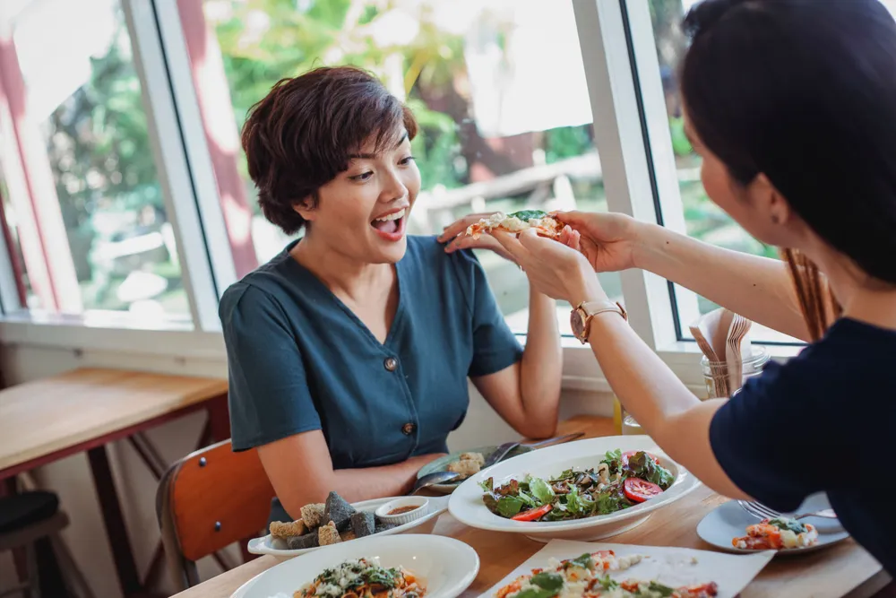 Friends&nbsp;sharing&nbsp;a&nbsp;meal&nbsp;at&nbsp;a&nbsp;community&nbsp;table