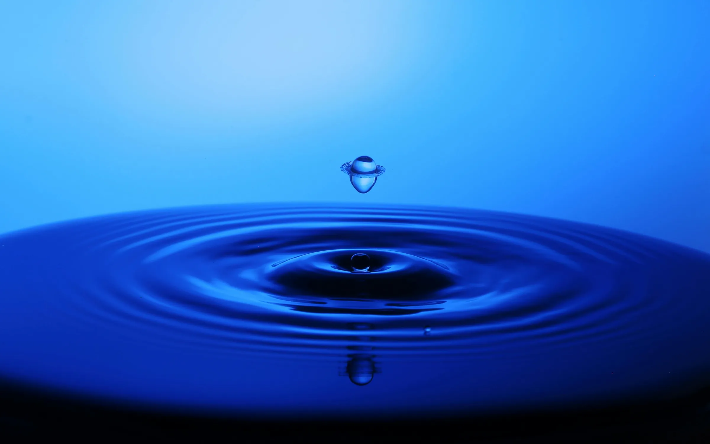 Water droplet falling into rippling water, representing process-water management