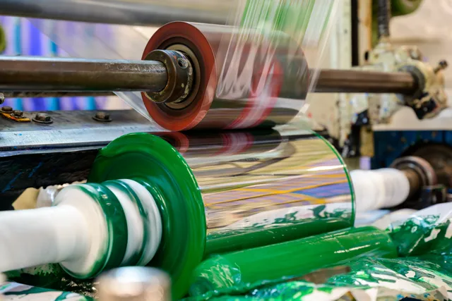 Flexible packaging film passing through printing rollers during polyamide ink trials